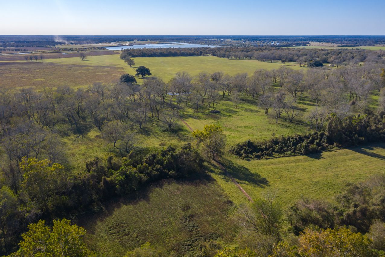aerial-of-bottomland-w-lake-in-back