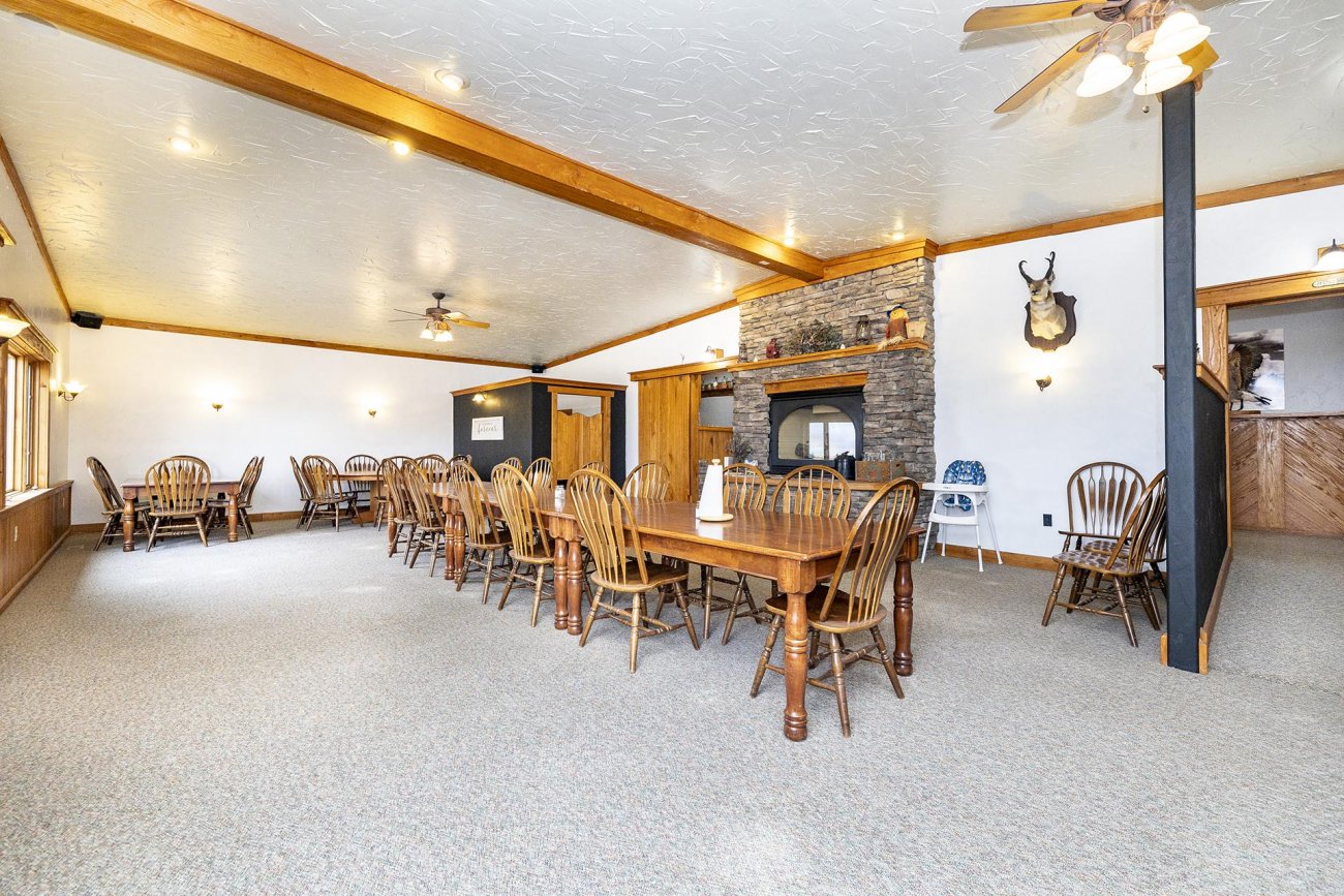 lodge-gathering-space-with-stone-fireplace-and-multiple-dining-tables-colorado-bow-barrel-lodge