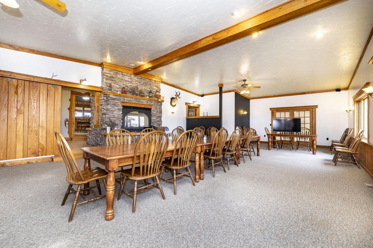 lodge-interior-featuring-long-wooden-dining-tables-and-stone-fireplace-colorado-bow-barrel-lodge
